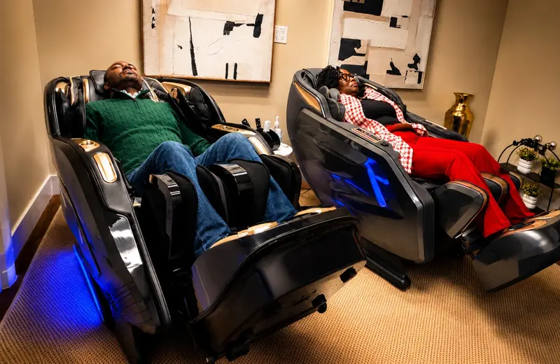 Two guests relaxing in massage chairs